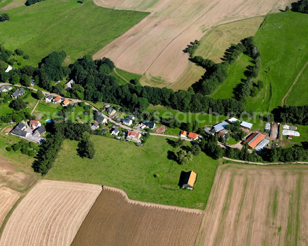 Hainichen from above - Agricultural land and field boundaries surround the settlement area of the village in Hainichen in the state Saxony, Germany