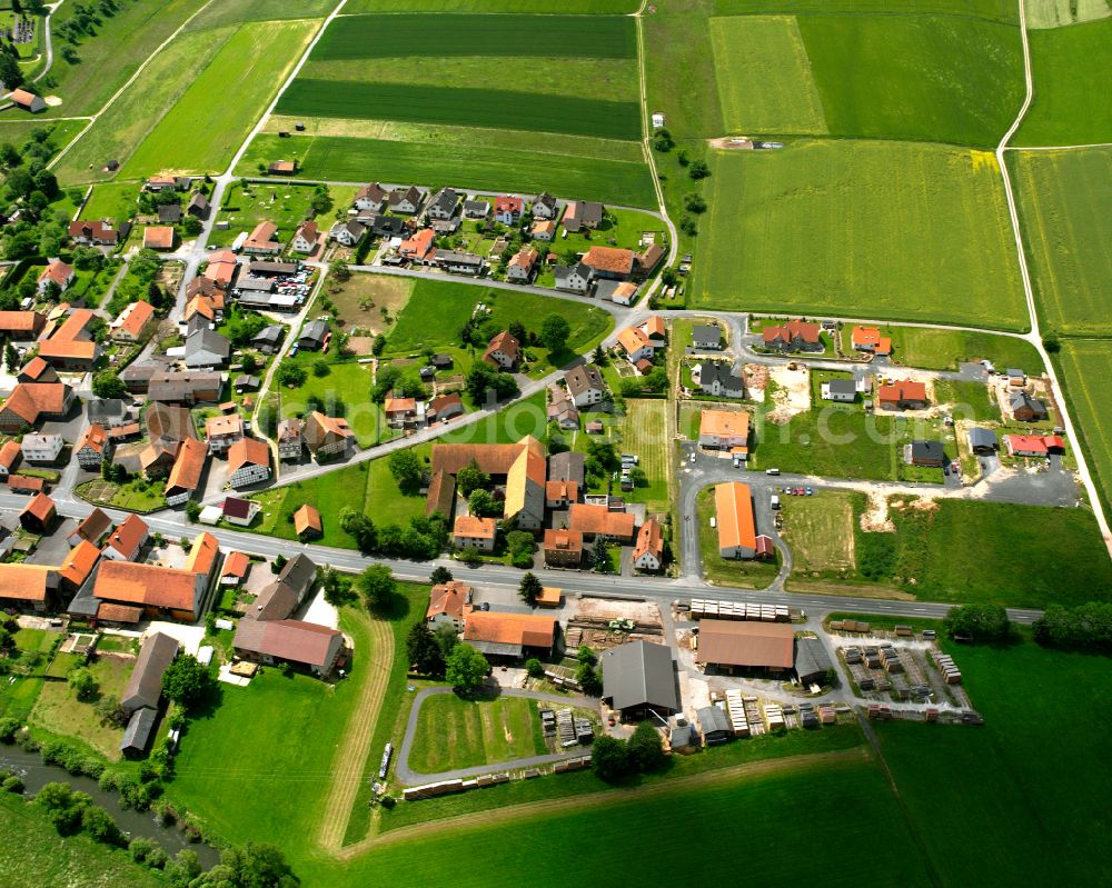 Aerial image Hartershausen - Agricultural land and field boundaries surround the settlement area of the village in Hartershausen in the state Hesse, Germany