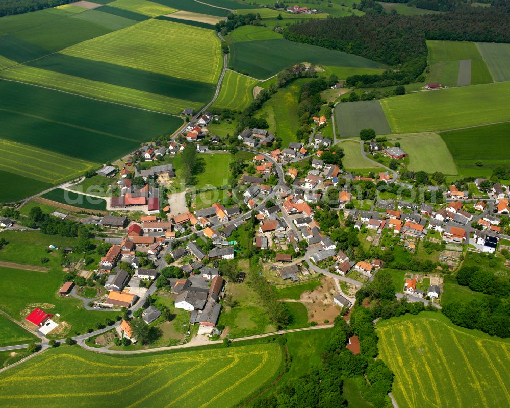 Hattendorf from above - Agricultural land and field boundaries surround the settlement area of the village in Hattendorf in the state Hesse, Germany