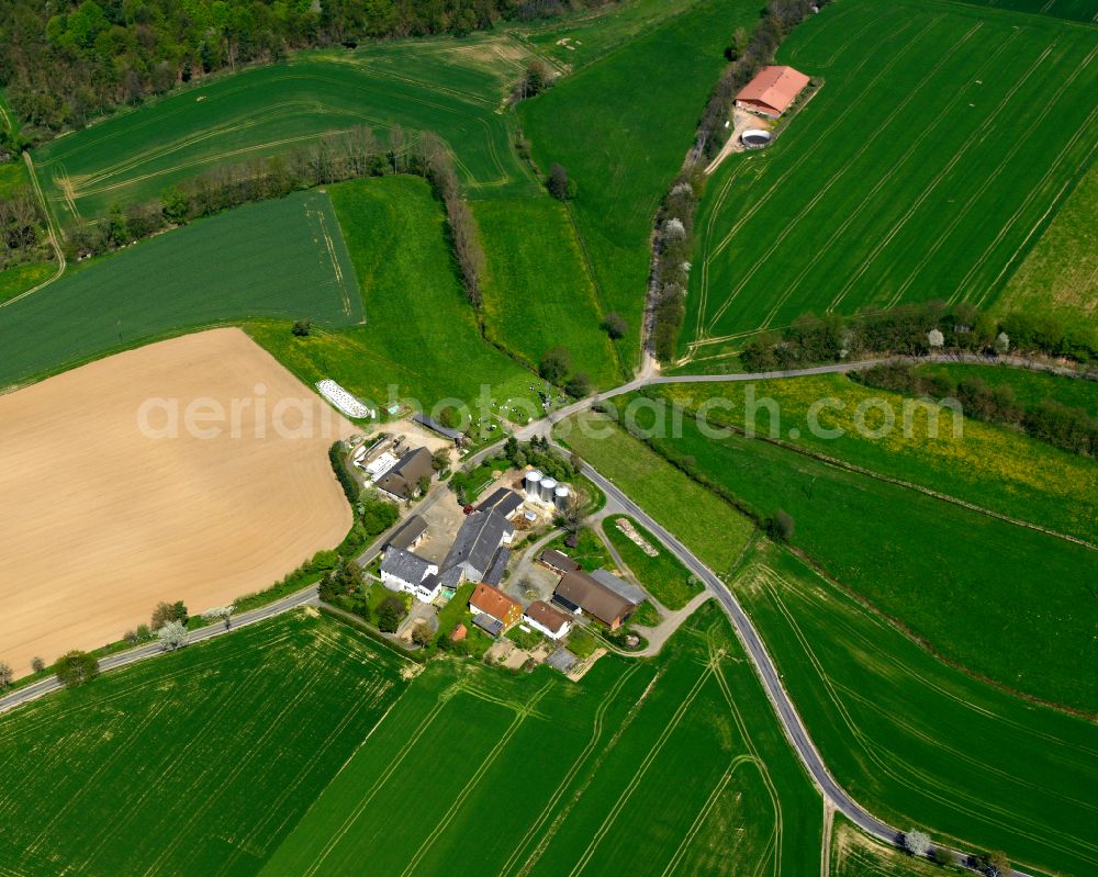 Hattendorf from above - Agricultural land and field boundaries surround the settlement area of the village in Hattendorf in the state Hesse, Germany