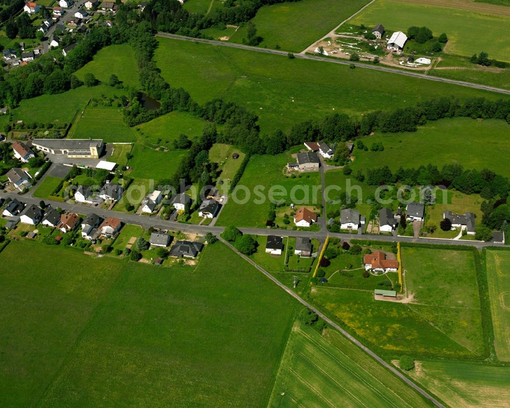 Hausen from above - Agricultural land and field boundaries surround the settlement area of the village in Hausen in the state Hesse, Germany