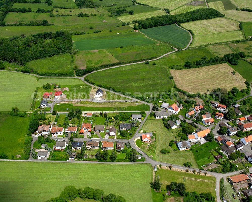 Höckersdorf from above - Agricultural land and field boundaries surround the settlement area of the village in Höckersdorf in the state Hesse, Germany