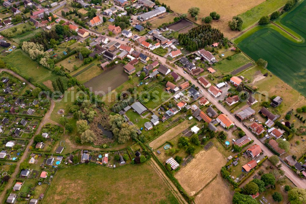 Heinersdorf from above - Agricultural land and field boundaries surround the settlement area of the village on street Lange Strasse in Heinersdorf in the state Brandenburg, Germany