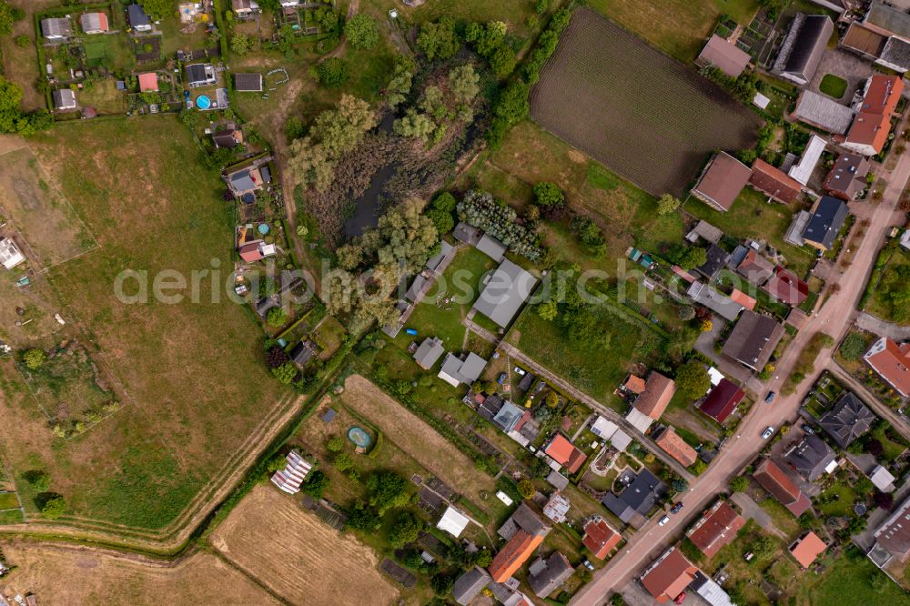 Heinersdorf from the bird's eye view: Agricultural land and field boundaries surround the settlement area of the village on street Lange Strasse in Heinersdorf in the state Brandenburg, Germany