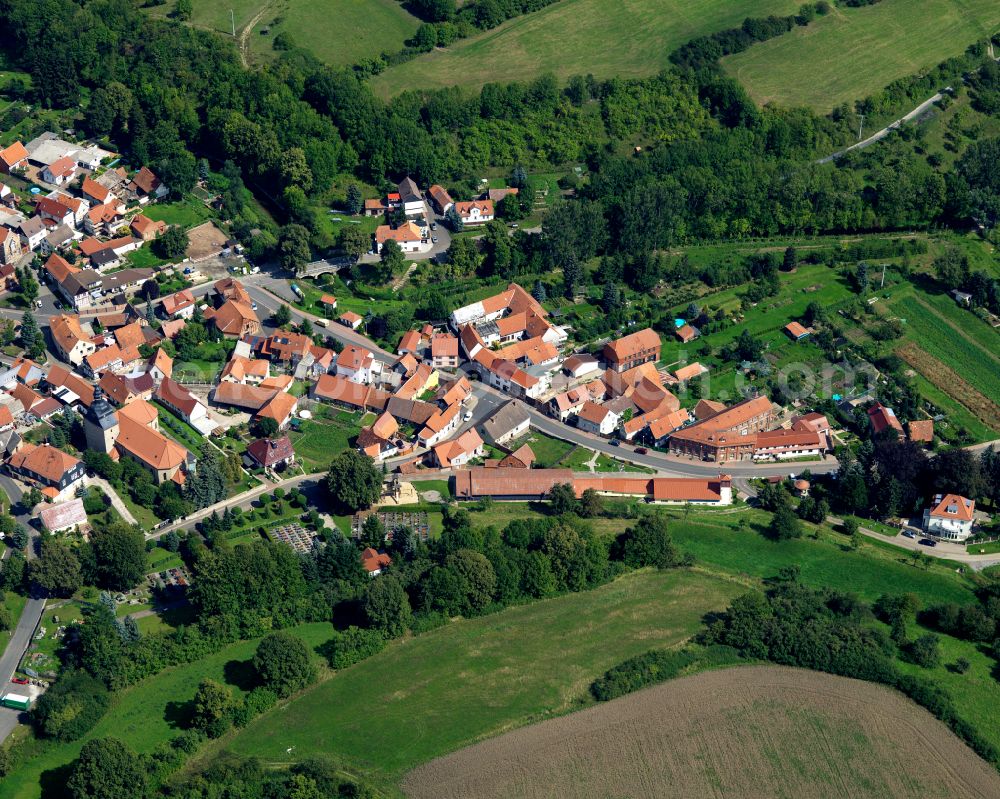 Helmsdorf from above - Agricultural land and field boundaries surround the settlement area of the village in Helmsdorf in the state Thuringia, Germany