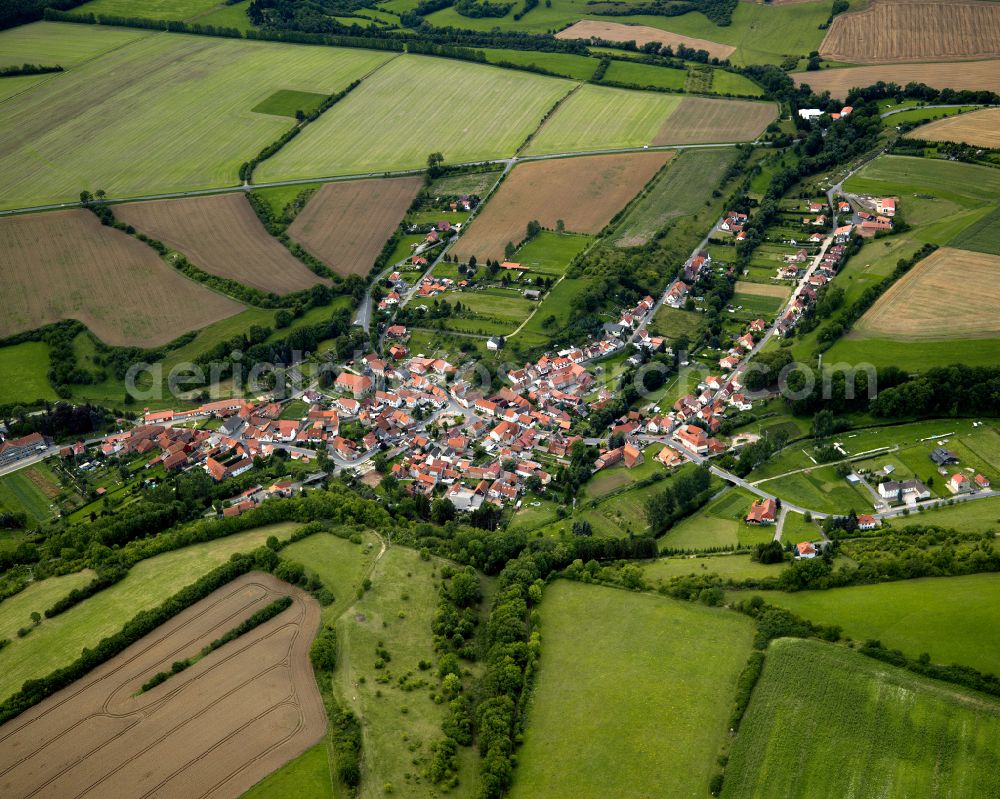 Helmsdorf from the bird's eye view: Agricultural land and field boundaries surround the settlement area of the village in Helmsdorf in the state Thuringia, Germany