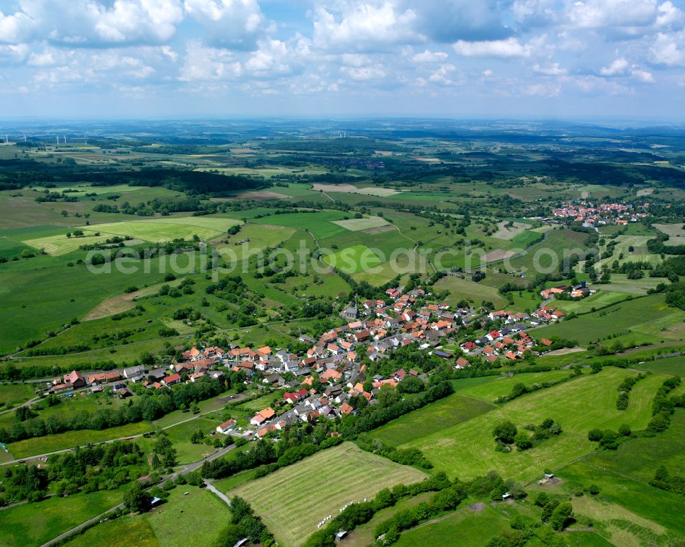 Aerial image Helpershain - Agricultural land and field boundaries surround the settlement area of the village in Helpershain in the state Hesse, Germany