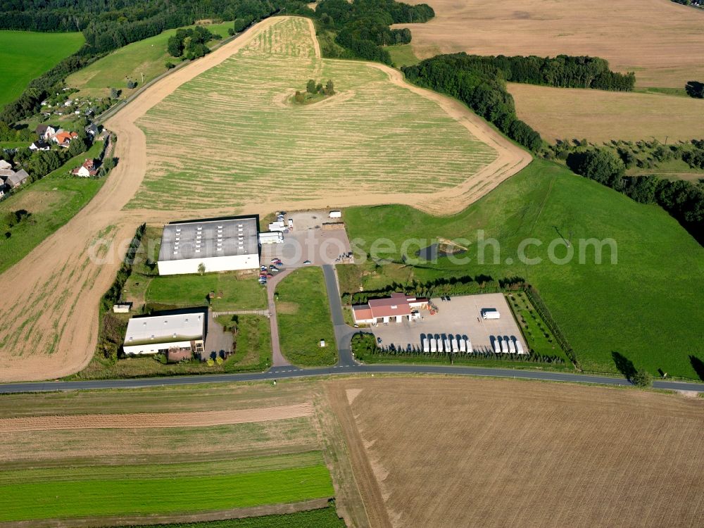 Hermsdorf from the bird's eye view: Agricultural land and field boundaries surround the settlement area of the village in Hermsdorf in the state Saxony, Germany