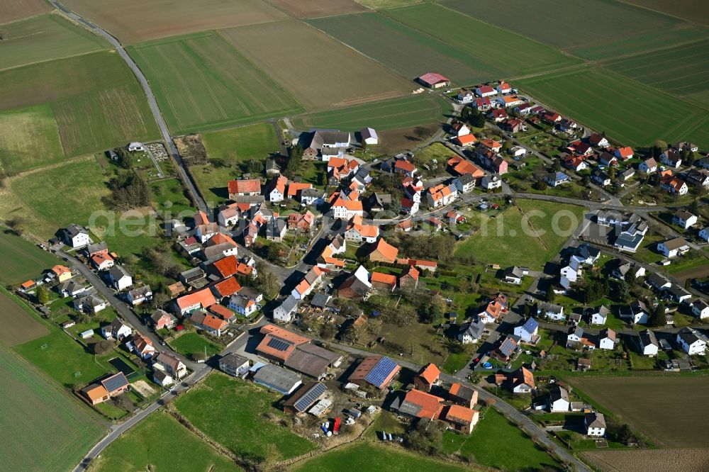 Heßlar from above - Agricultural land and field boundaries surround the settlement area of the village in Heßlar in the state Hesse, Germany