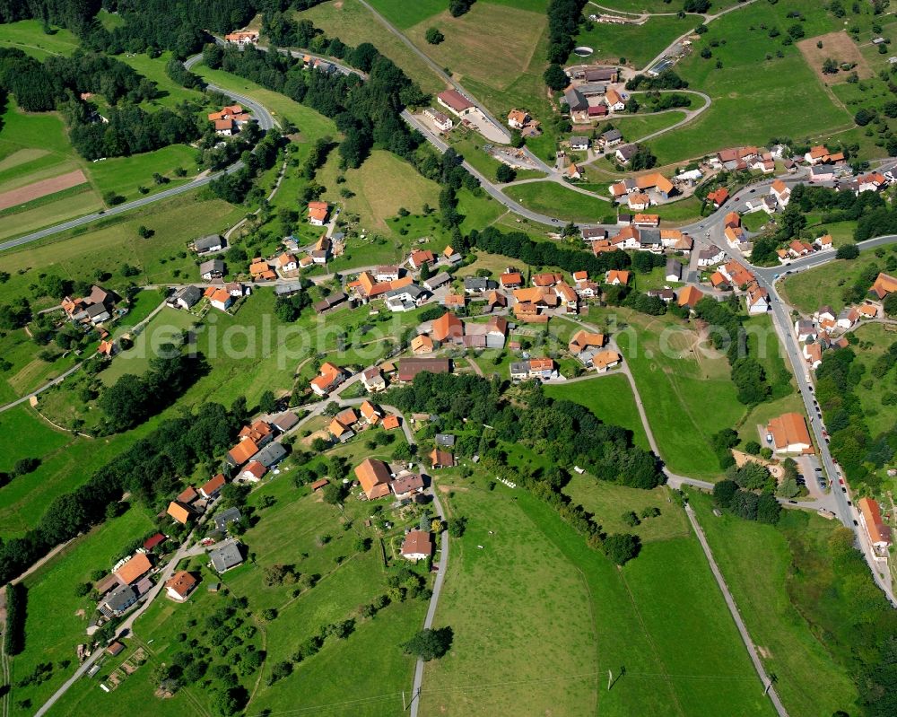 Hetzbach from above - Agricultural land and field boundaries surround the settlement area of the village in Hetzbach in the state Hesse, Germany