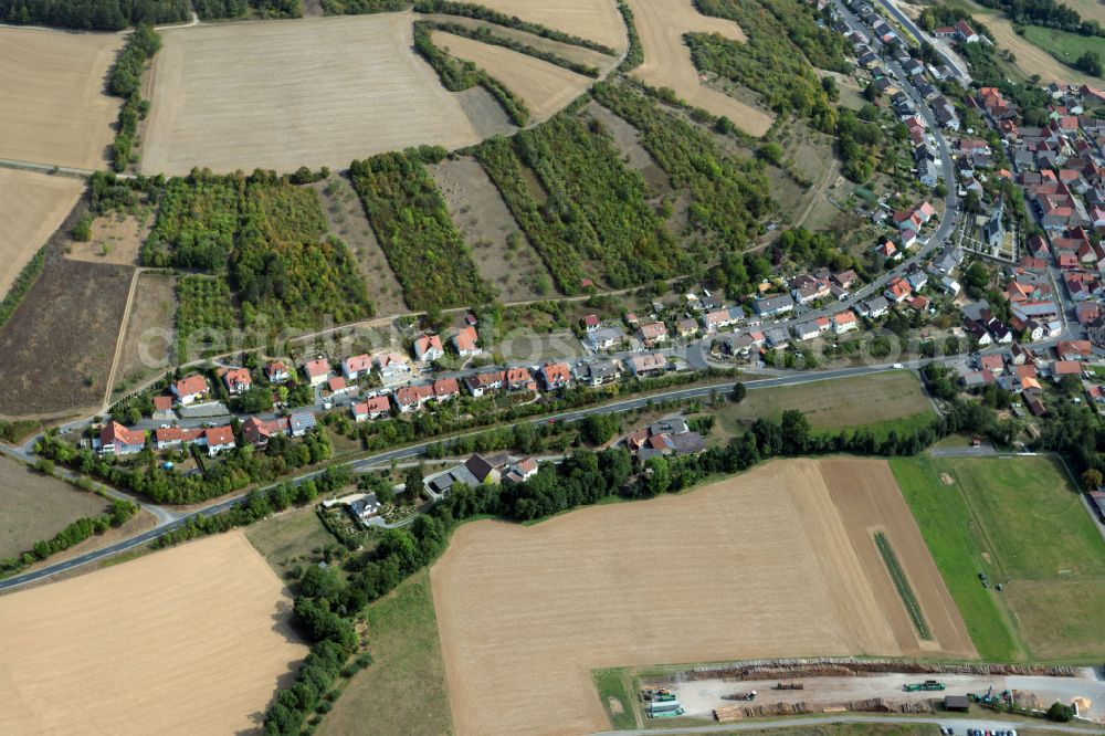 Heugrumbach from above - Agricultural land and field boundaries surround the settlement area of the village in Heugrumbach in the state Bavaria, Germany