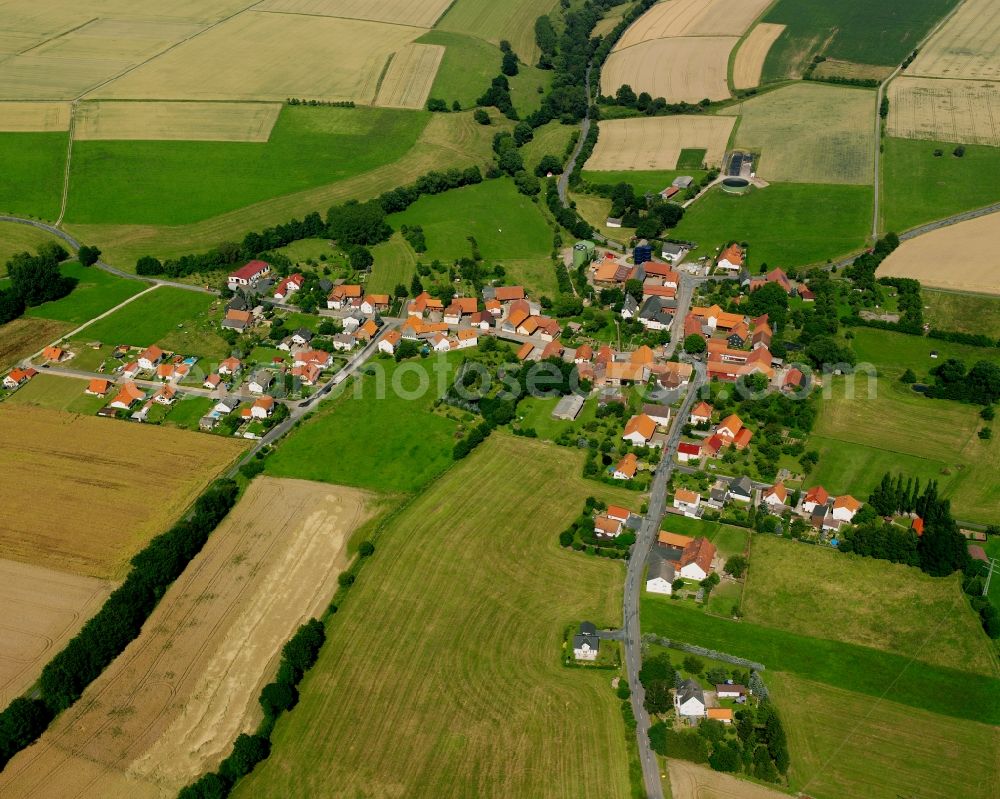 Hillartshausen from above - Agricultural land and field boundaries surround the settlement area of the village in Hillartshausen in the state Hesse, Germany