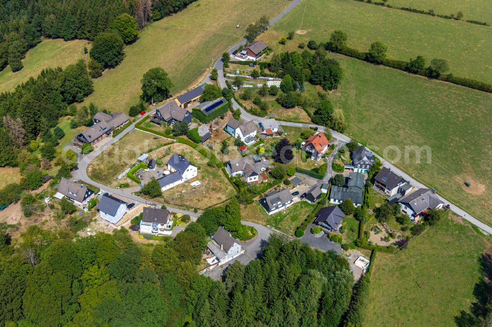 Hillringhausen from the bird's eye view: Agricultural land and field boundaries surround the settlement area of the village in Hillringhausen in the state North Rhine-Westphalia, Germany