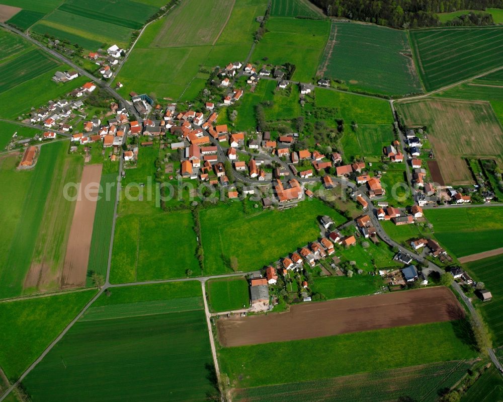 Hilmes from above - Agricultural land and field boundaries surround the settlement area of the village in Hilmes in the state Hesse, Germany