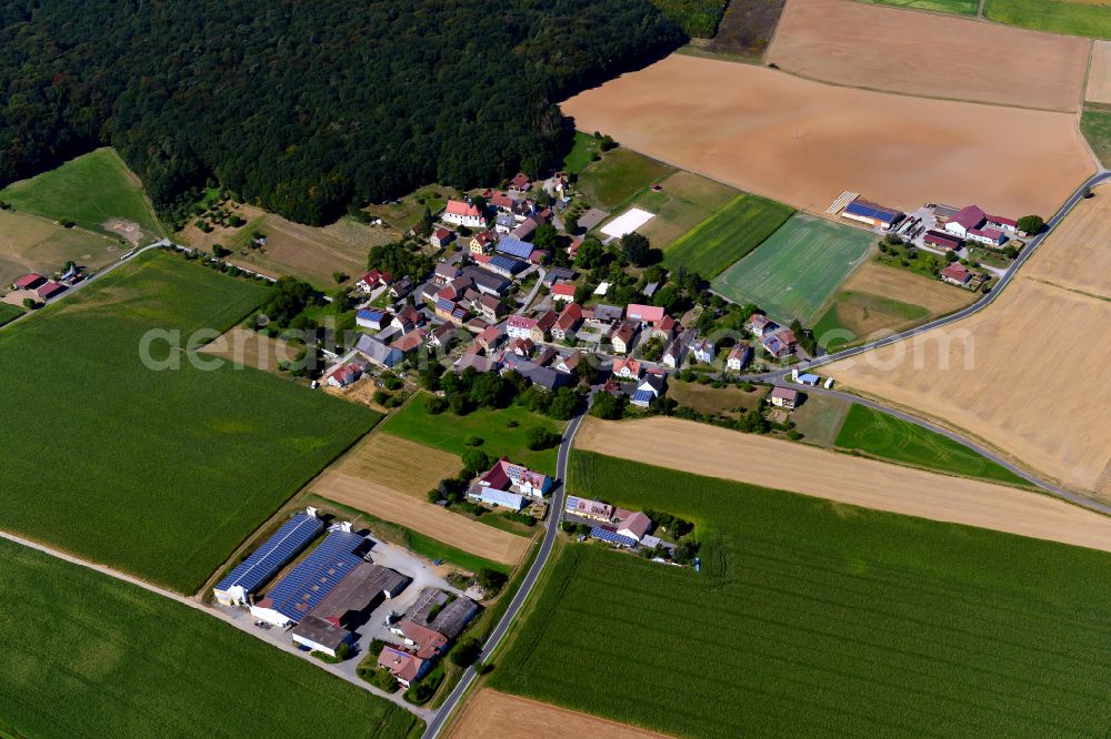 Hilpertshausen from above - Agricultural land and field boundaries surround the settlement area of the village in Hilpertshausen in the state Bavaria, Germany