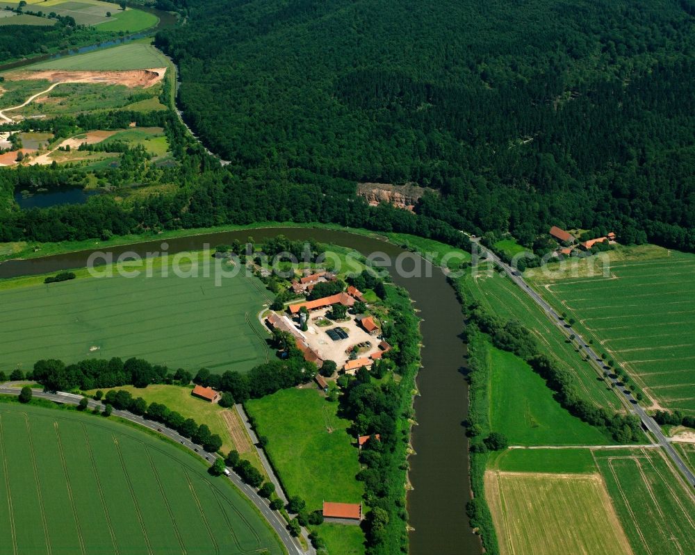 Hilwartshausen from the bird's eye view: Agricultural land and field boundaries surround the settlement area of the village in Hilwartshausen in the state Lower Saxony, Germany