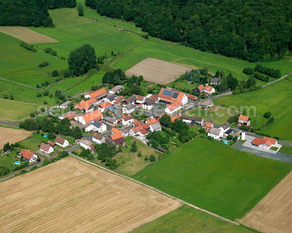 Höingen from the bird's eye view: Agricultural land and field boundaries surround the settlement area of the village in Höingen in the state Hesse, Germany