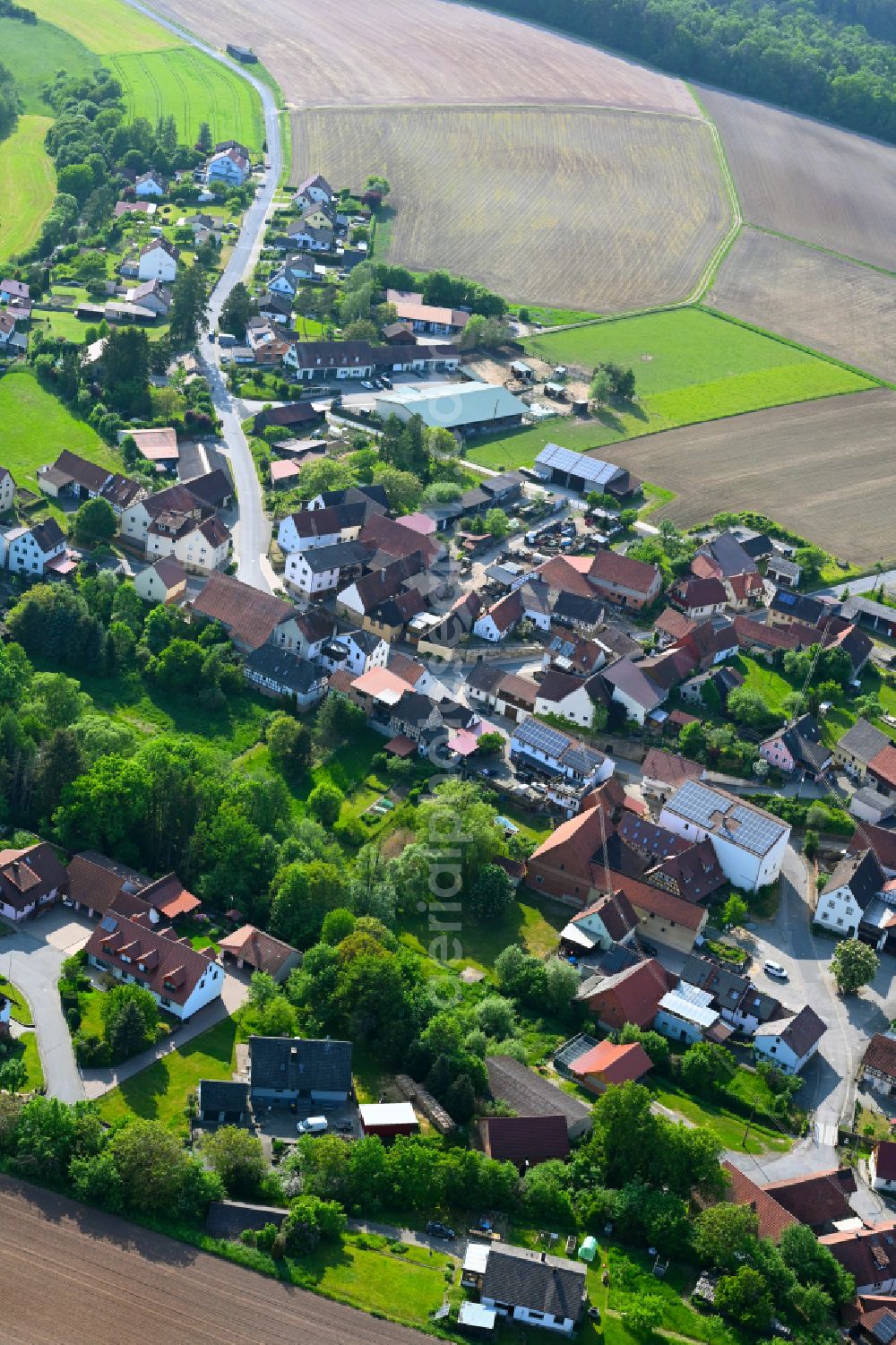 Hohnhausen from the bird's eye view: Agricultural land and field boundaries surround the settlement area of the village in Hohnhausen in the state Bavaria, Germany