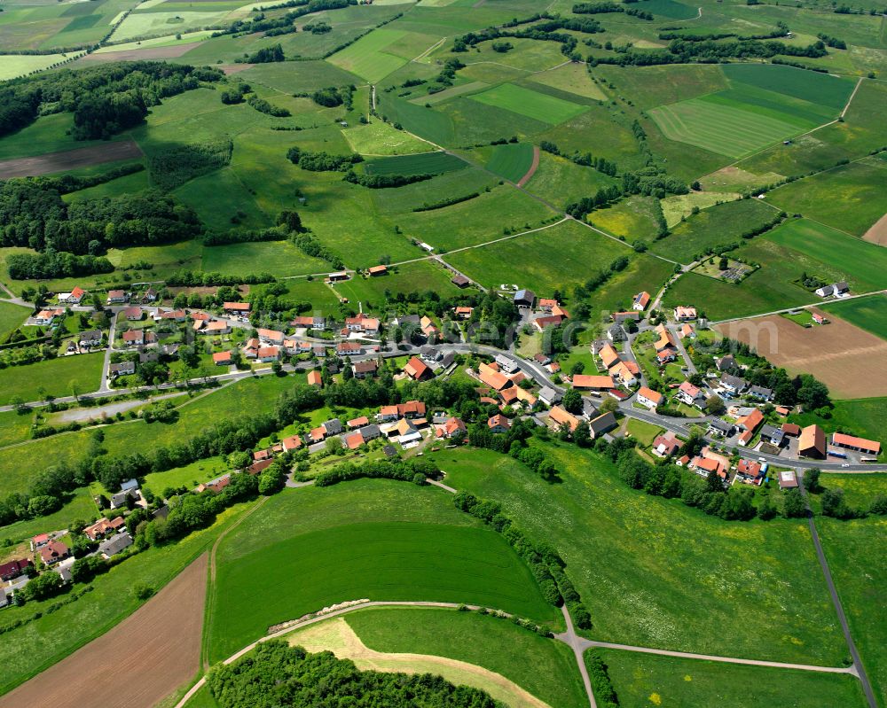 Holzmühl from above - Agricultural land and field boundaries surround the settlement area of the village in Holzmühl in the state Hesse, Germany