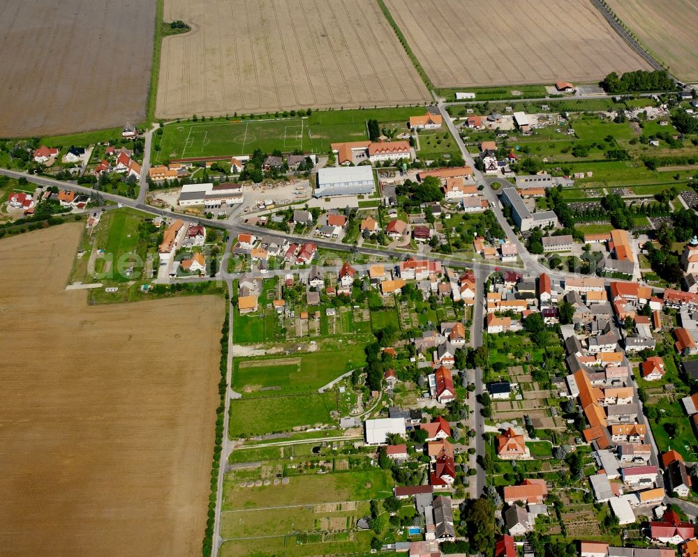 Hüpstedt from the bird's eye view: Agricultural land and field boundaries surround the settlement area of the village in Hüpstedt in the state Thuringia, Germany