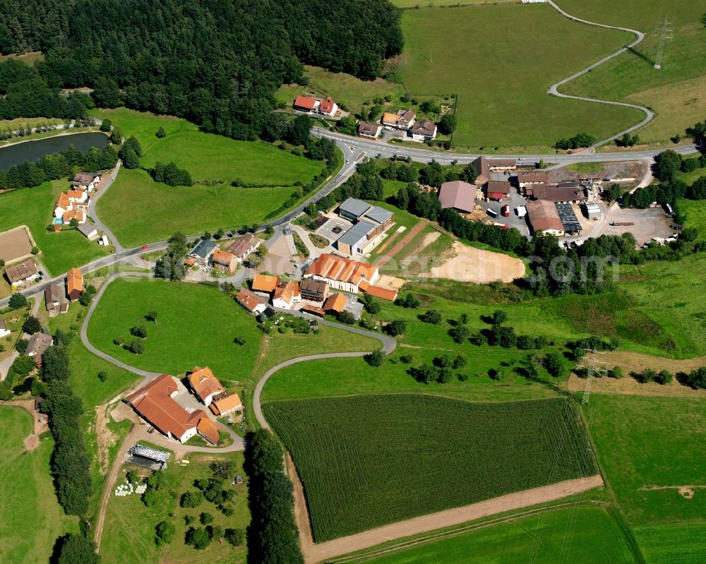 Aerial photograph Hüttenthal - Agricultural land and field boundaries surround the settlement area of the village in Hüttenthal in the state Hesse, Germany