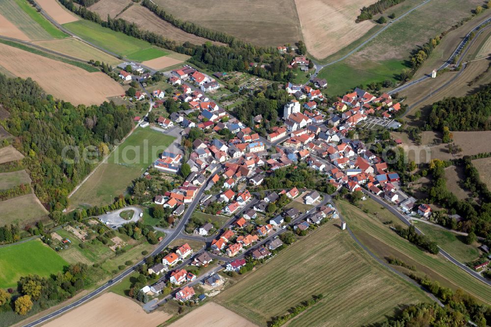 Hundsbach from above - Agricultural land and field boundaries surround the settlement area of the village in Hundsbach in the state Bavaria, Germany