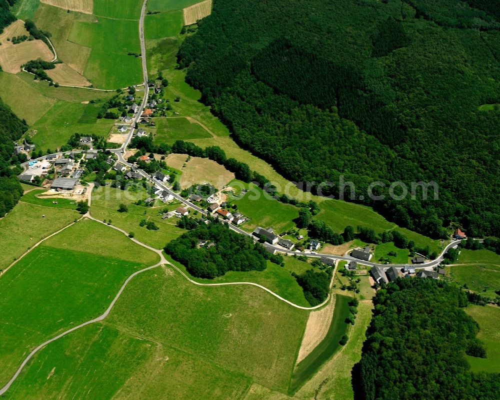 Hußweiler from above - Agricultural land and field boundaries surround the settlement area of the village in Hußweiler in the state Rhineland-Palatinate, Germany