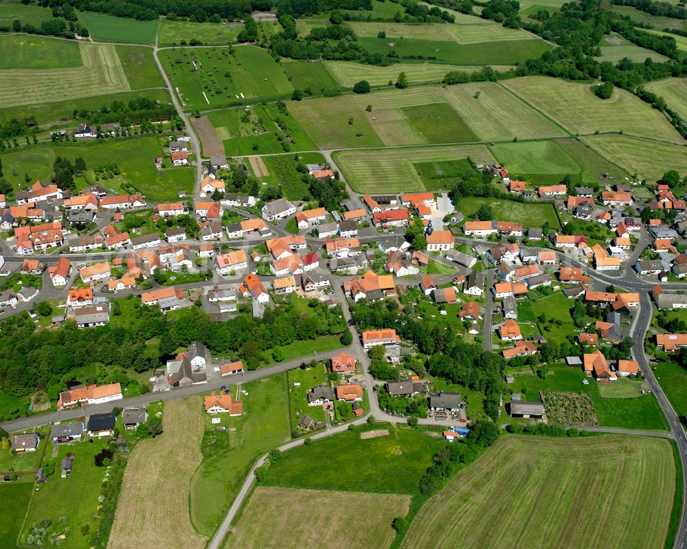 Aerial photograph Ilbeshausen-Hochwaldhausen - Agricultural land and field boundaries surround the settlement area of the village in Ilbeshausen-Hochwaldhausen in the state Hesse, Germany