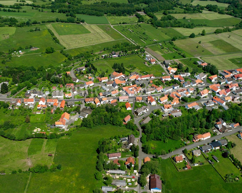 Ilbeshausen-Hochwaldhausen from above - Agricultural land and field boundaries surround the settlement area of the village in Ilbeshausen-Hochwaldhausen in the state Hesse, Germany