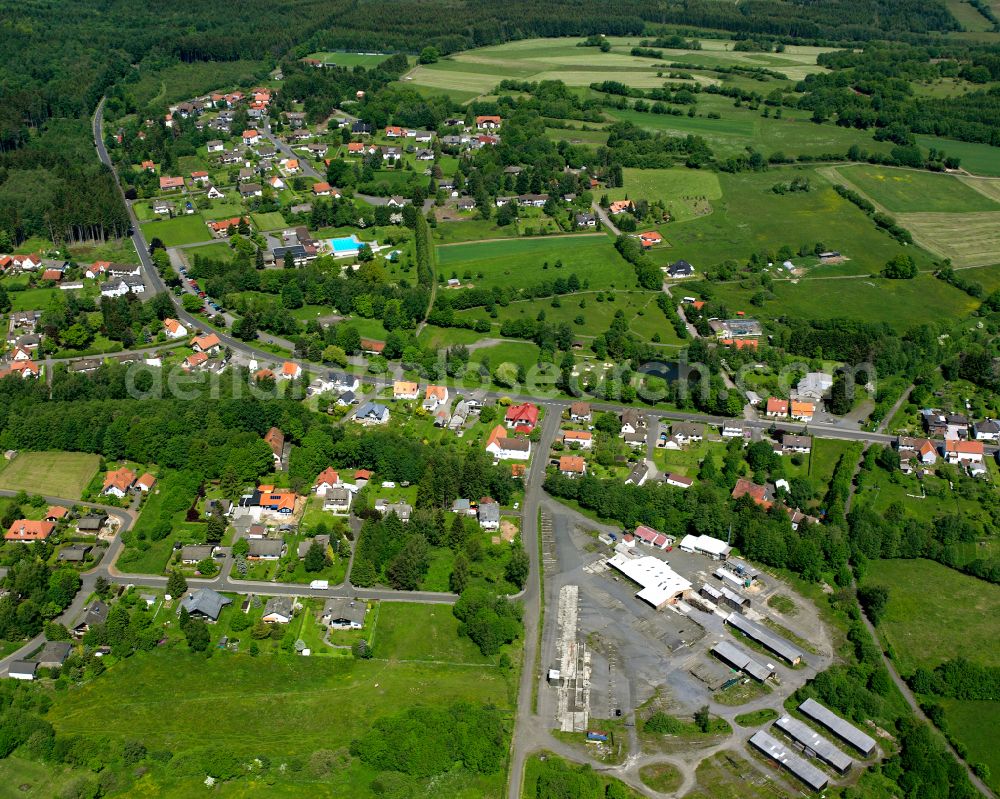 Aerial image Ilbeshausen-Hochwaldhausen - Agricultural land and field boundaries surround the settlement area of the village in Ilbeshausen-Hochwaldhausen in the state Hesse, Germany