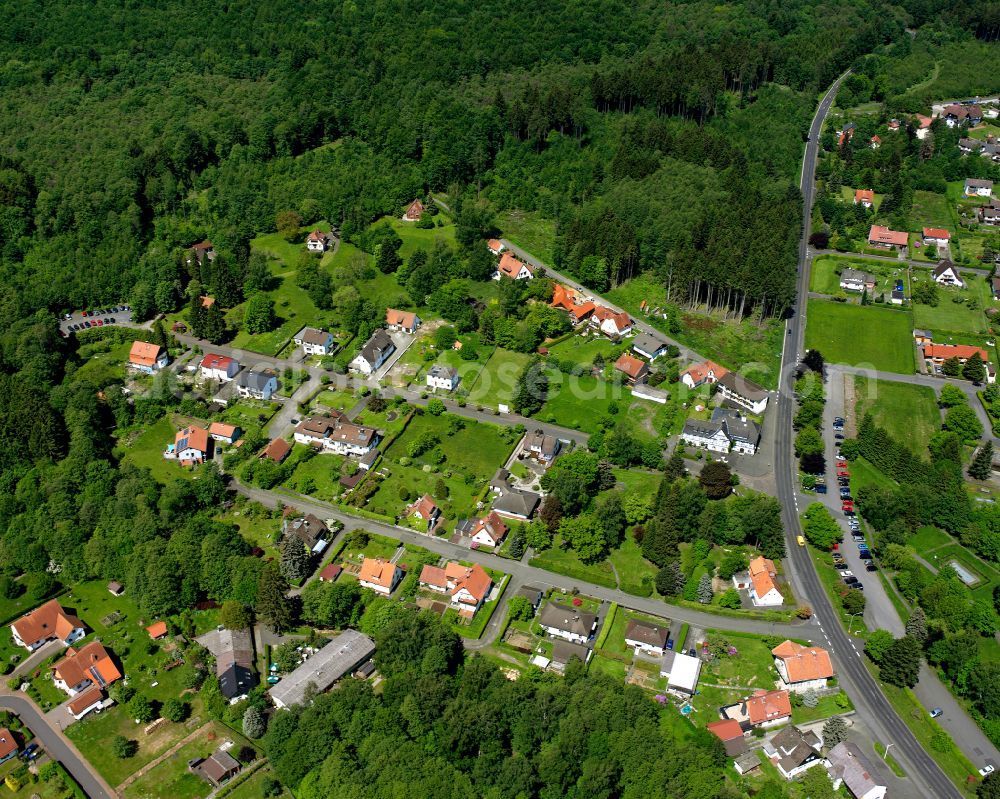 Ilbeshausen-Hochwaldhausen from above - Agricultural land and field boundaries surround the settlement area of the village in Ilbeshausen-Hochwaldhausen in the state Hesse, Germany