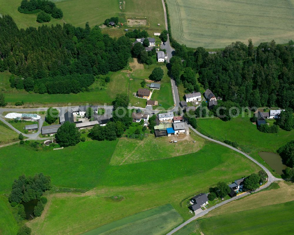 Issigau from the bird's eye view: Agricultural land and field boundaries surround the settlement area of the village in Issigau in the state Bavaria, Germany