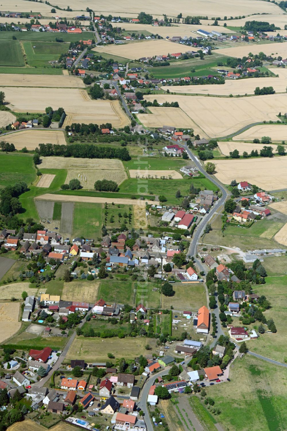 Kakau from the bird's eye view: Agricultural land and field boundaries surround the settlement area of the village in Kakau in the state Saxony-Anhalt, Germany