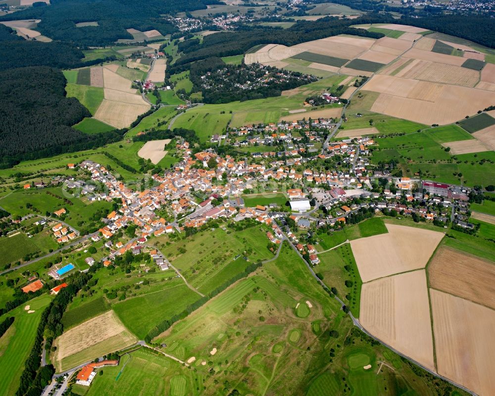 Kirchbrombach from above - Agricultural land and field boundaries surround the settlement area of the village in Kirchbrombach in the state Hesse, Germany