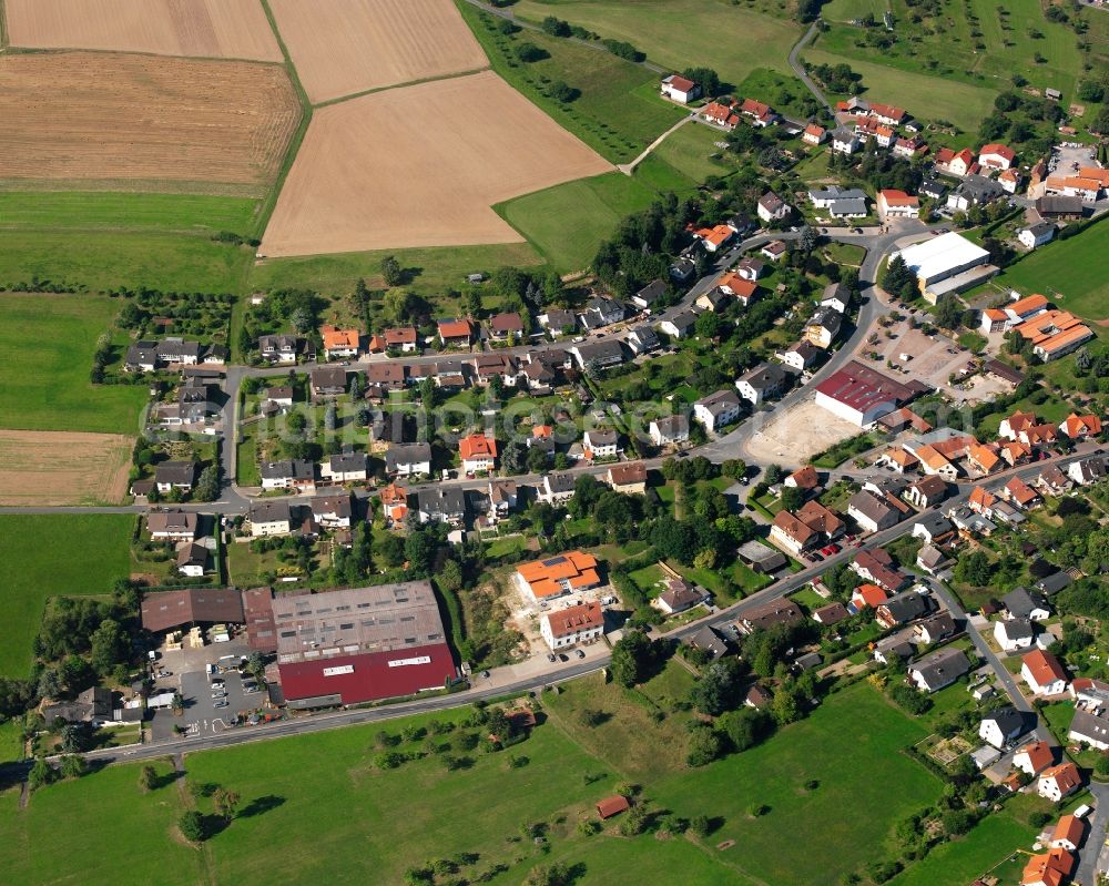 Aerial photograph Kirchbrombach - Agricultural land and field boundaries surround the settlement area of the village in Kirchbrombach in the state Hesse, Germany