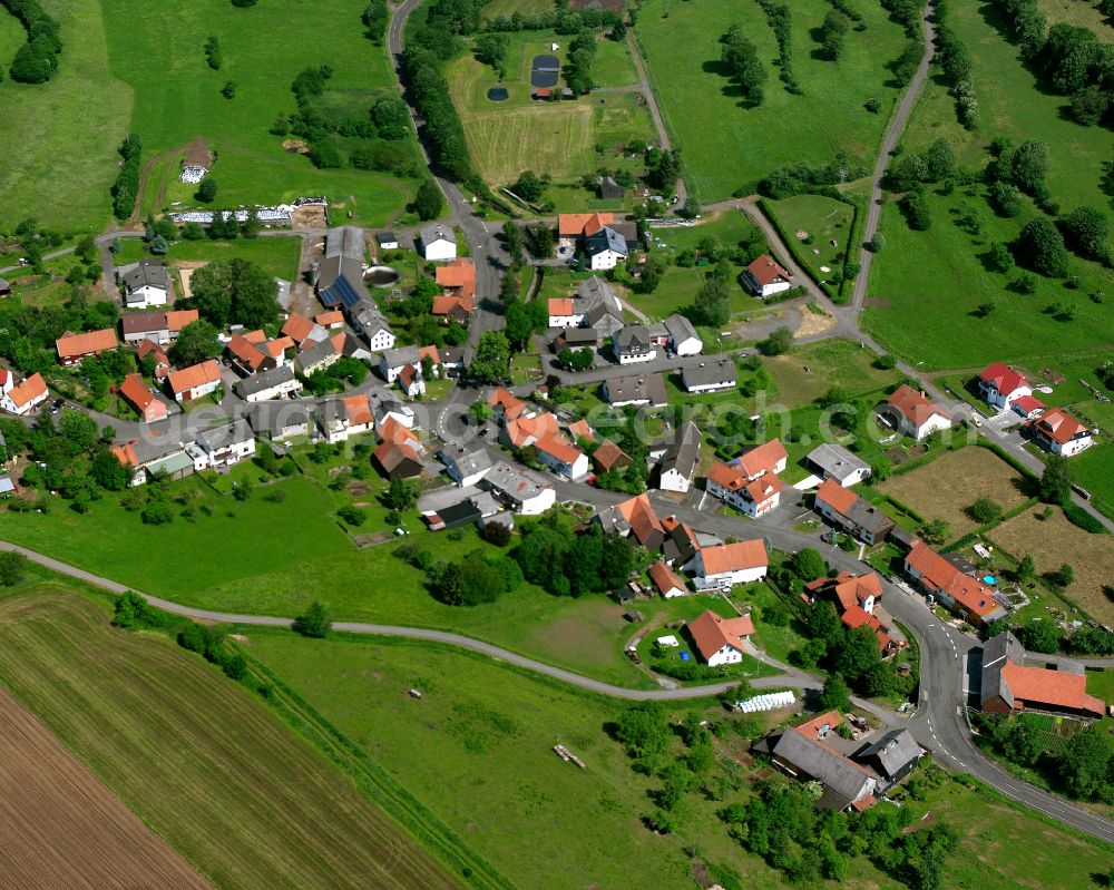 Kölzenhain from the bird's eye view: Agricultural land and field boundaries surround the settlement area of the village in Kölzenhain in the state Hesse, Germany