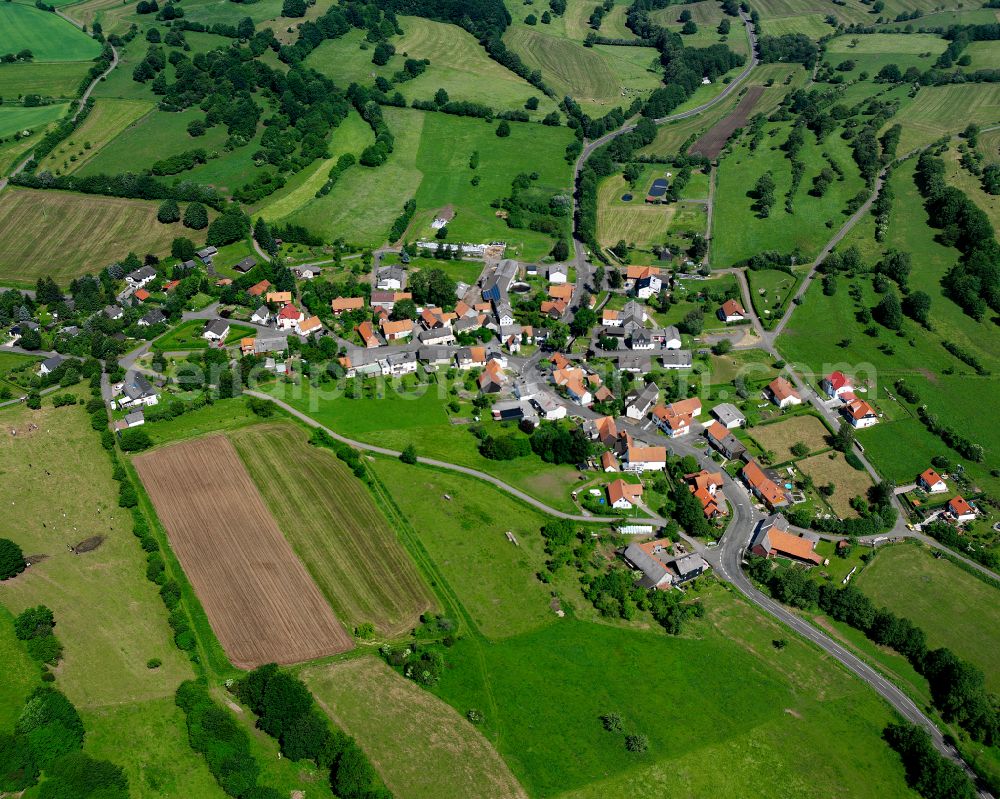 Aerial image Kölzenhain - Agricultural land and field boundaries surround the settlement area of the village in Kölzenhain in the state Hesse, Germany