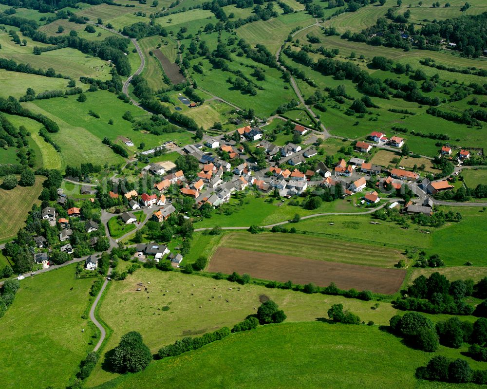 Aerial photograph Kölzenhain - Agricultural land and field boundaries surround the settlement area of the village in Kölzenhain in the state Hesse, Germany