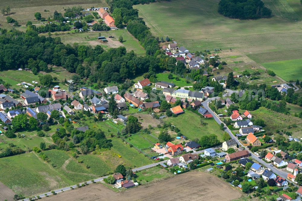 Aerial photograph Koßwig - Agricultural land and field boundaries surround the settlement area of the village on street Kosswiger Dorfstrasse in Kosswig in the state Brandenburg, Germany