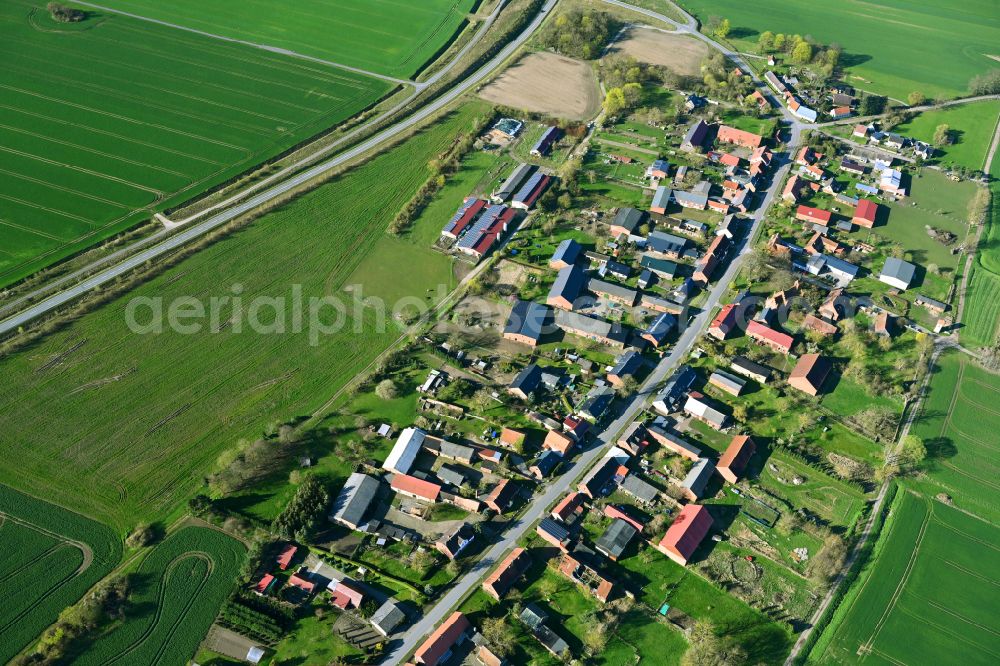 Kuhbier from above - Agricultural land and field boundaries surround the settlement area of the village in Kuhbier in the state Brandenburg, Germany