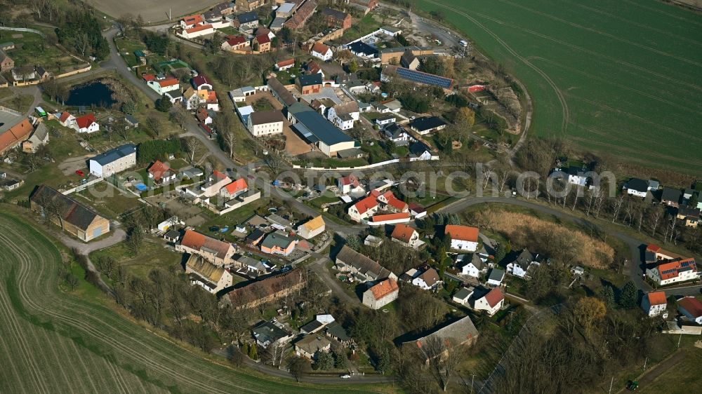 Kyhna from the bird's eye view: Agricultural land and field boundaries surround the settlement area of the village in Kyhna in the state Saxony, Germany