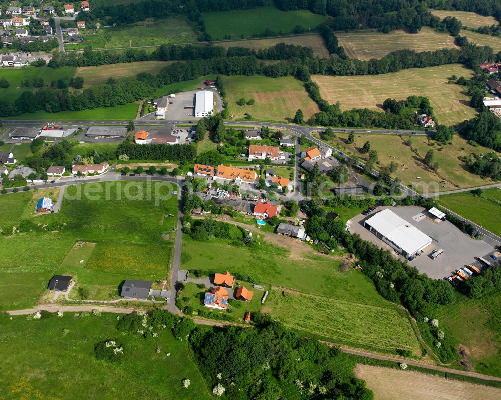 Aerial photograph Langemühle - Agricultural land and field boundaries surround the settlement area of the village in Langemühle in the state Hesse, Germany