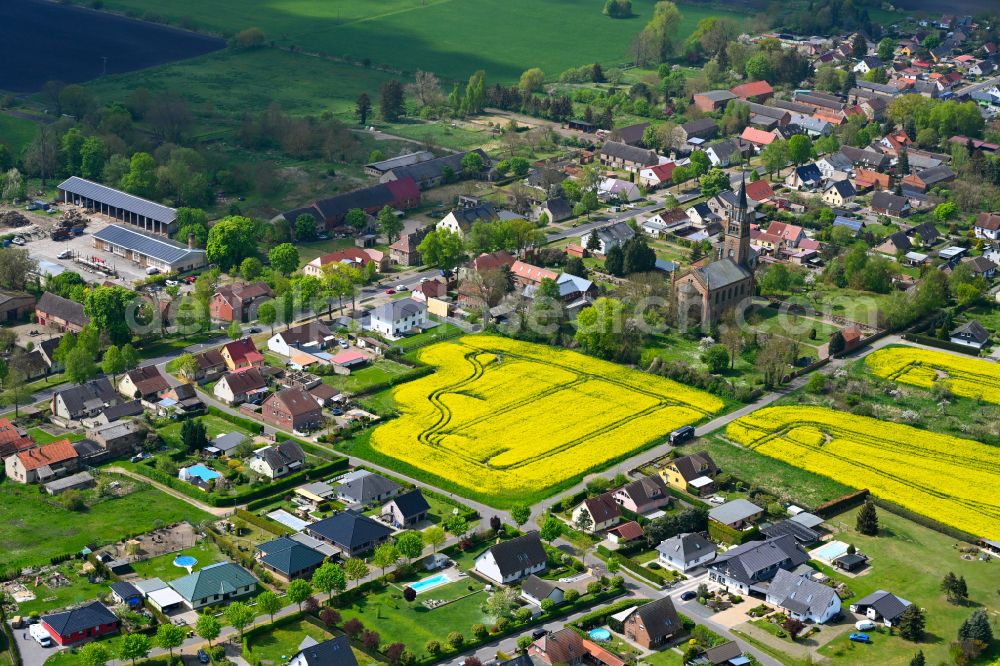 Langen from above - Agricultural land and field boundaries surround the settlement area of the village in Langen in the state Brandenburg, Germany