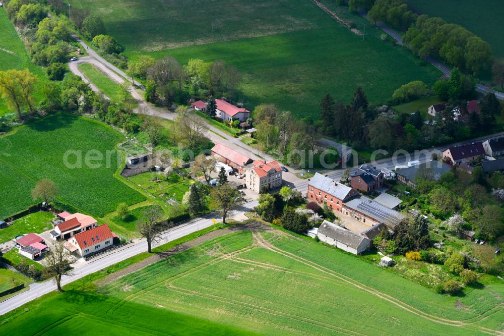 Langen from above - Agricultural land and field boundaries surround the settlement area of the village in Langen in the state Brandenburg, Germany