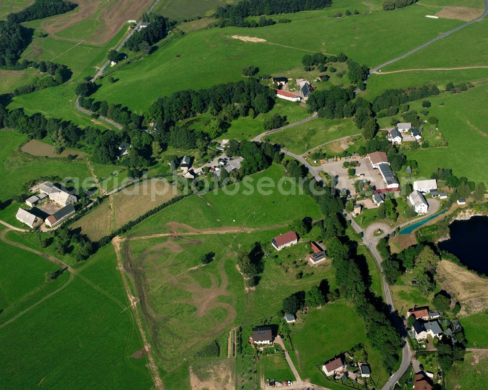 Langenstriegis from the bird's eye view: Agricultural land and field boundaries surround the settlement area of the village in Langenstriegis in the state Saxony, Germany