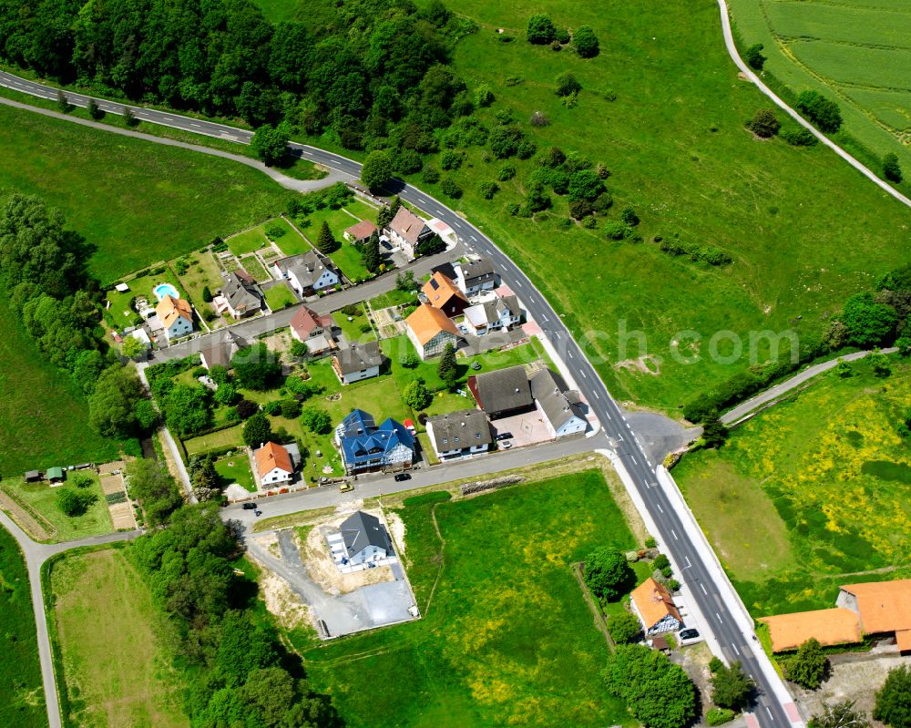 Lehrbach from the bird's eye view: Agricultural land and field boundaries surround the settlement area of the village in Lehrbach in the state Hesse, Germany