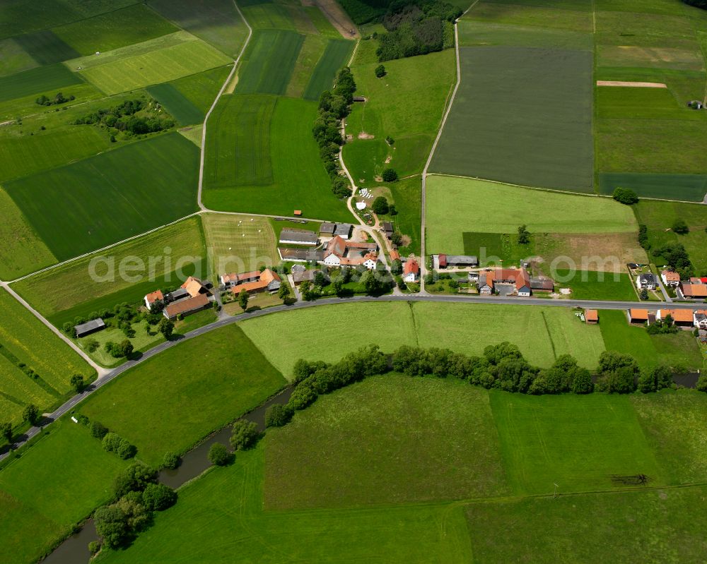 Üllershausen from the bird's eye view: Agricultural land and field boundaries surround the settlement area of the village in Üllershausen in the state Hesse, Germany