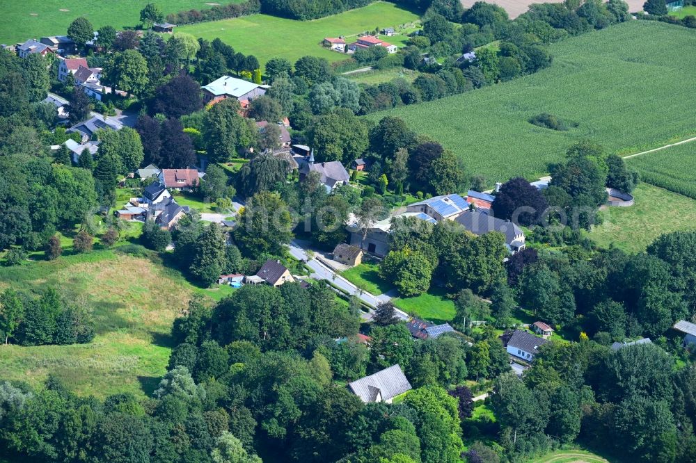 Loit from above - Agricultural land and field boundaries surround the settlement area of the village in Loit in the state Schleswig-Holstein, Germany