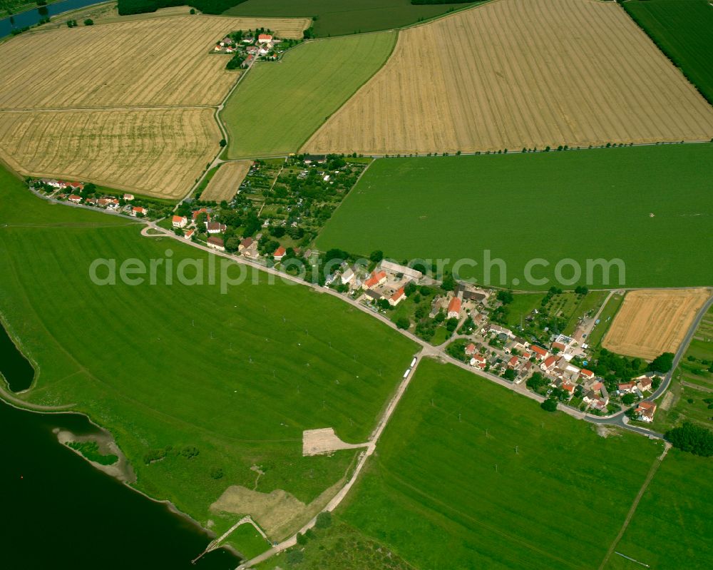 Lorenzkirch from the bird's eye view: Agricultural land and field boundaries surround the settlement area of the village in Lorenzkirch in the state Saxony, Germany