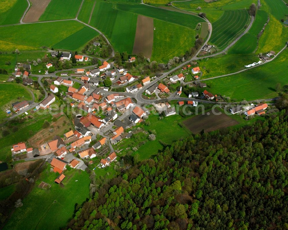 Machtlos from above - Agricultural land and field boundaries surround the settlement area of the village in Machtlos in the state Hesse, Germany